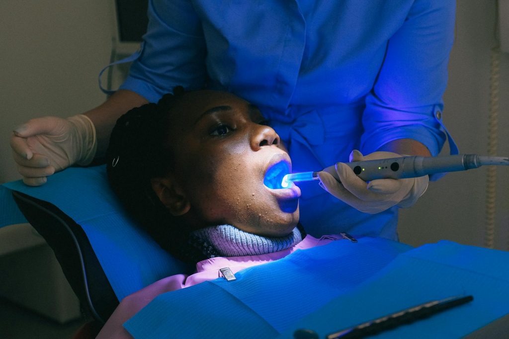 young ethnic female patient treating teeth in modern clinic
